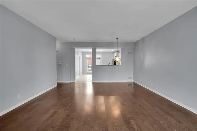 a view of a big room with wooden floor and windows