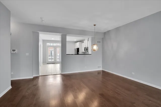 a view of a kitchen with wooden floor and a window