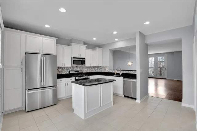 a kitchen with stainless steel appliances granite countertop a refrigerator a stove a sink and a refrigerator