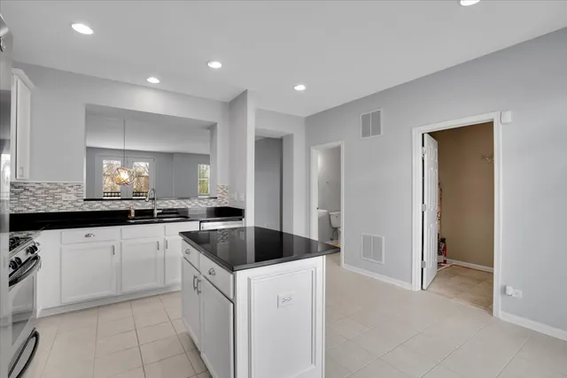 a kitchen with granite countertop a sink and white cabinets