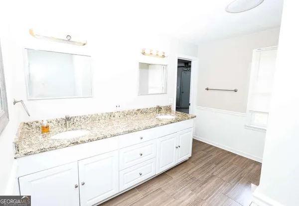 a bathroom with a granite countertop sink and a mirror