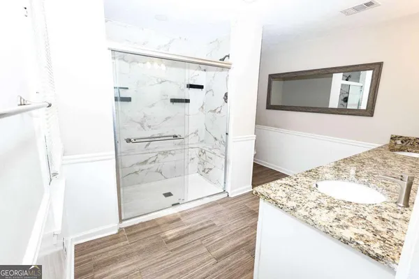 a bathroom with a granite countertop mirror and a shower