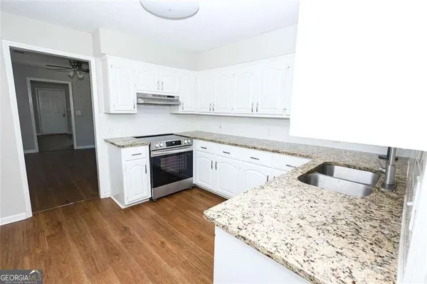 a kitchen with stainless steel appliances granite countertop a sink and stove top oven