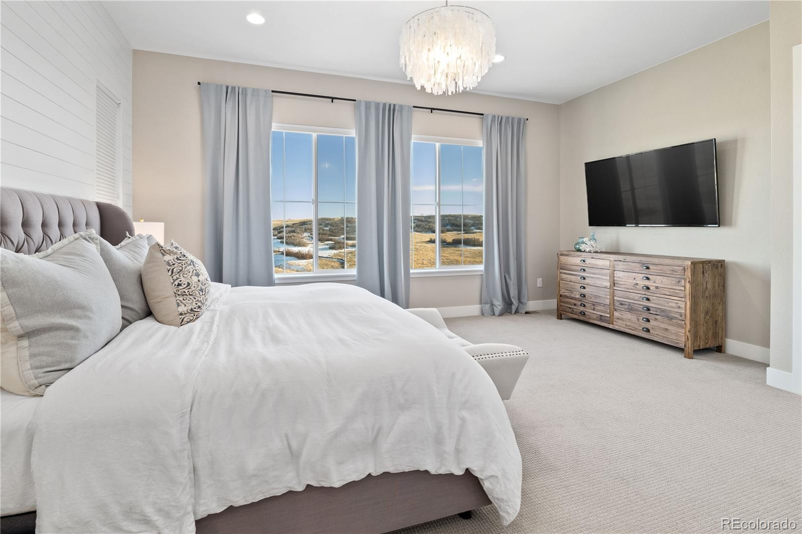 6976 Rim Ridge Drive Castle Pines, CO 80108 - Photo 15 of 50 a spacious bedroom with a bed and flat screen tv