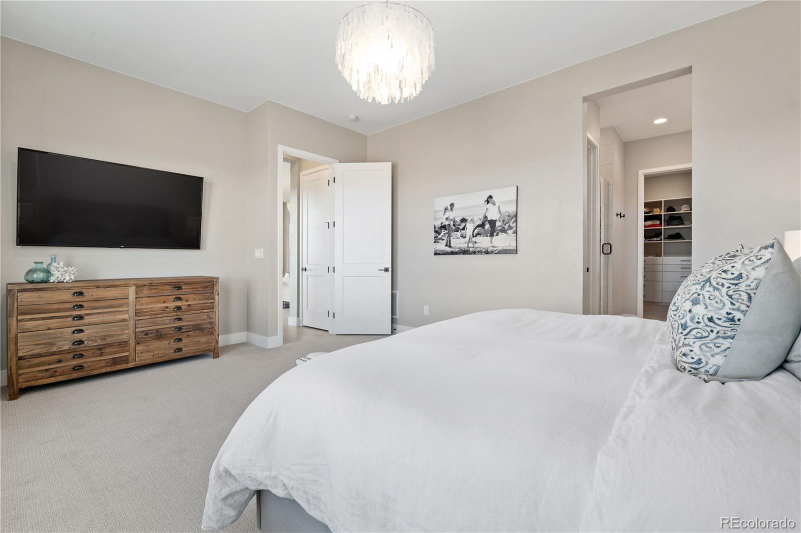 6976 Rim Ridge Drive Castle Pines, CO 80108 - Photo 27 of 50 a bedroom with a bed and a flat screen tv