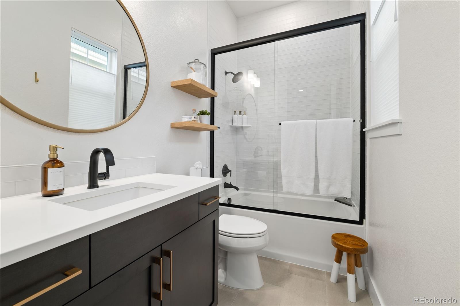 6976 Rim Ridge Drive Castle Pines, CO 80108 - Photo 31 of 50 a bathroom with a sink a toilet and a mirror