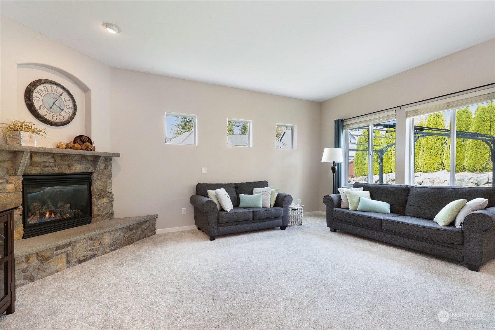 1227 187th Street Southeast Bothell, WA 98012 - Photo 16 of 38 a living room with furniture a clock and a fireplace