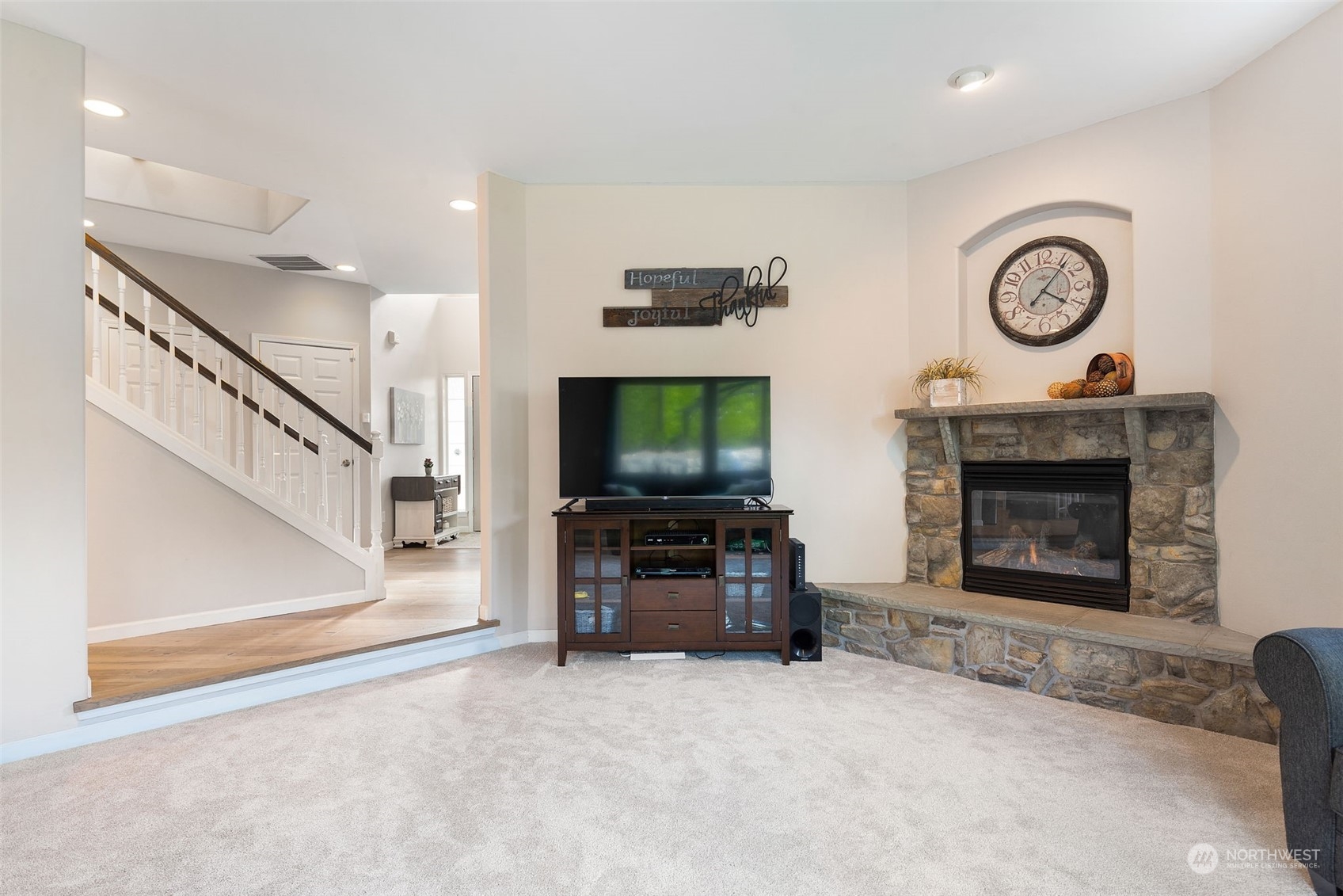 1227 187th Street Southeast Bothell, WA 98012 - Photo 18 of 38 a living room with furniture a clock and a flat screen tv