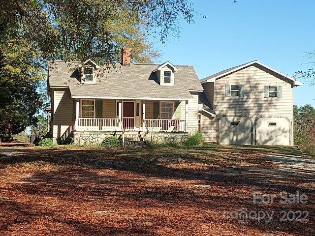671 Jess Lamb Road Rutherfordton, NC 28139 - Photo 1 of 31 a view of a white house next to a yard with large trees