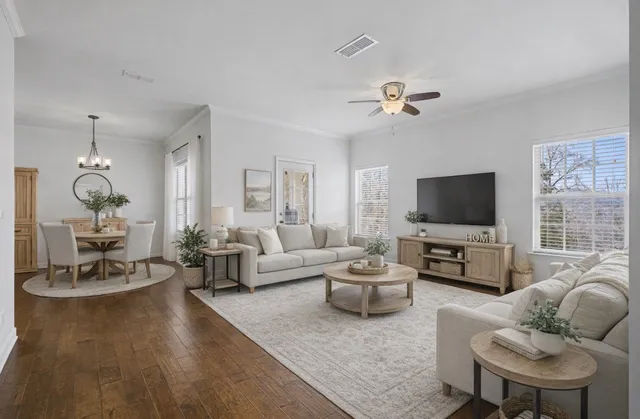 a living room with furniture a flat screen tv and a large window