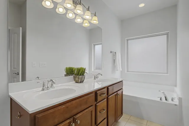 a bathroom with a sink a vanity a mirror and a bathtub with a mirror