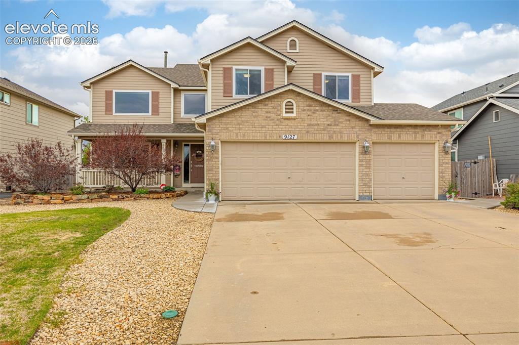 9127 Oakmont Road Peyton, CO 80831 - Photo 1 of 49 a front view of a house with a yard and garage