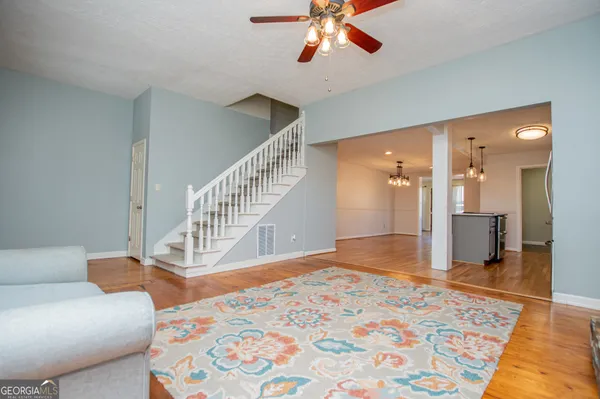 a kitchen with stainless steel appliances granite countertop a refrigerator a sink dishwasher and white countertops with wooden floor