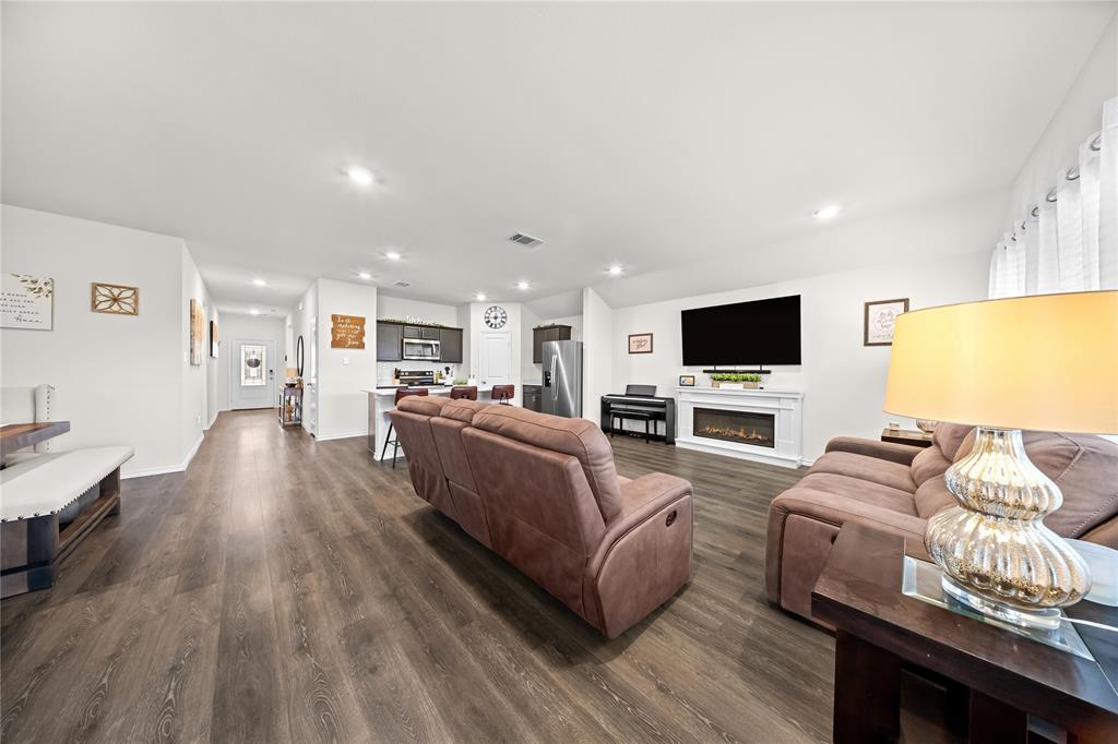 2920 Roper Street Royse City, TX 75189 - Photo 15 of 29 Open-concept living area featuring wood-finish flooring, recessed lighting, and a modern electric fireplace with a white mantel