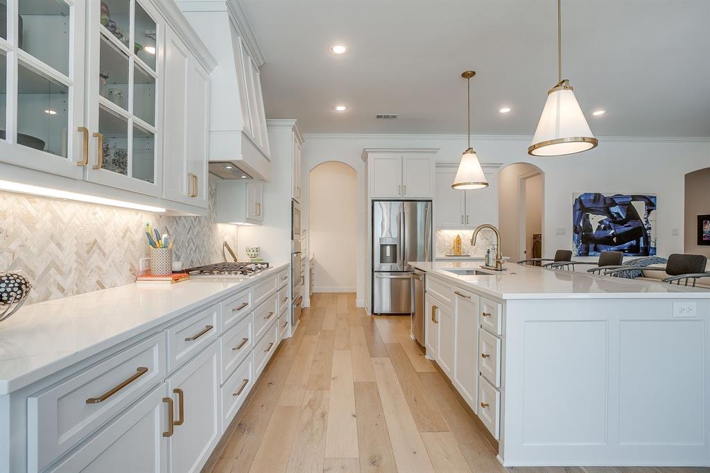 413 Kestrel Court Aledo, TX 76008 - Photo 15 of 40 a large kitchen with kitchen island a sink a counter space a stove and a chandelier