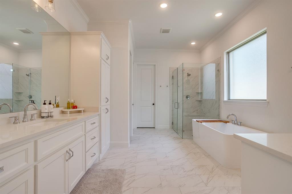 413 Kestrel Court Aledo, TX 76008 - Photo 24 of 40 a spacious bathroom with double vanity a mirror a bathtub and shower