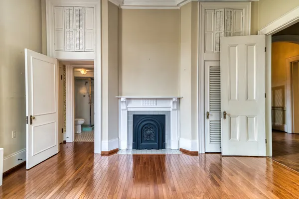 a view of a livingroom with wooden floor a fireplace and entryway