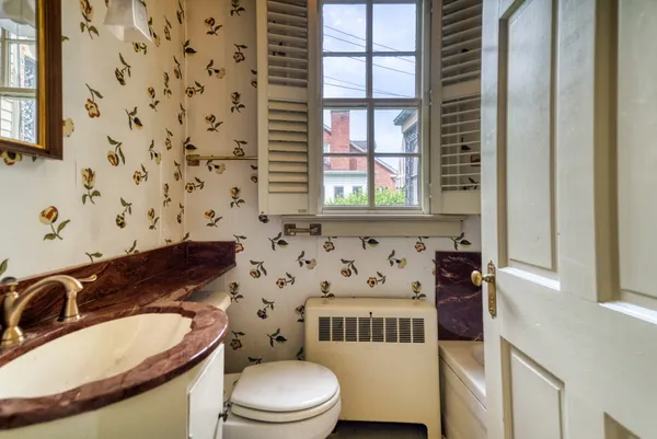 a bathroom with a toilet a sink and a mirror