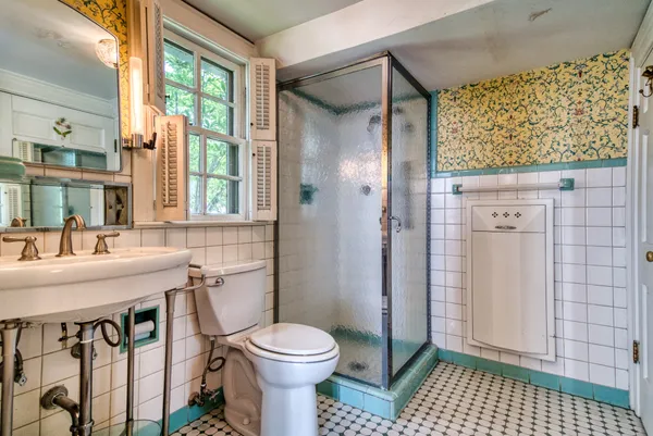 a bathroom with a sink a toilet and shower