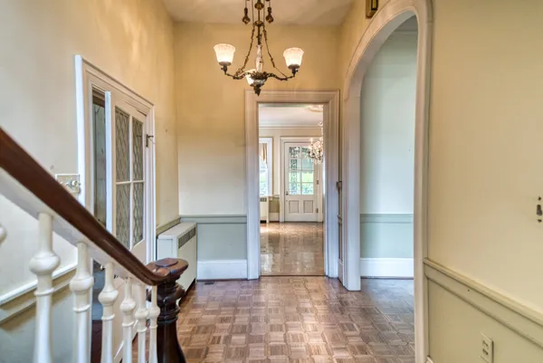a view of a hallway with wooden floor and staircase