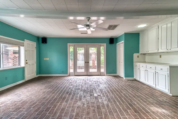 a view of an empty room with a window and wooden floor