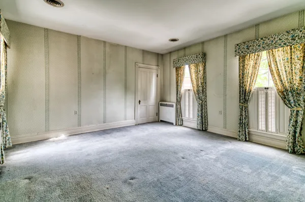 an empty room with windows and closet