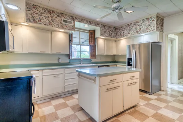 a kitchen with a refrigerator a sink and cabinets