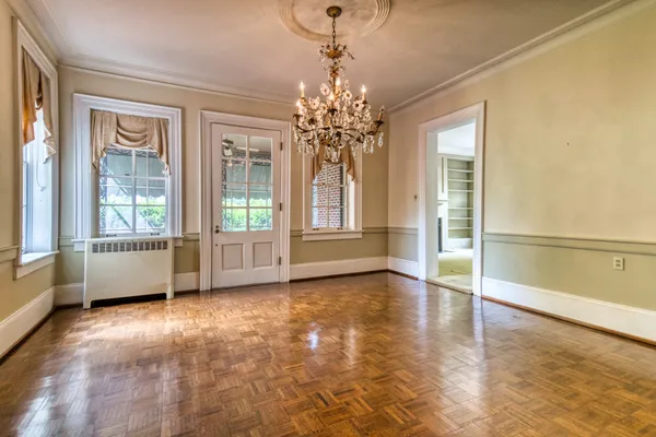 a view of an empty room with a window and wooden floor