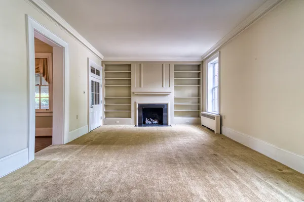 a view of an empty room with a fireplace and a window