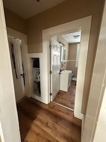 a view of a hallway with wooden floor and a living room