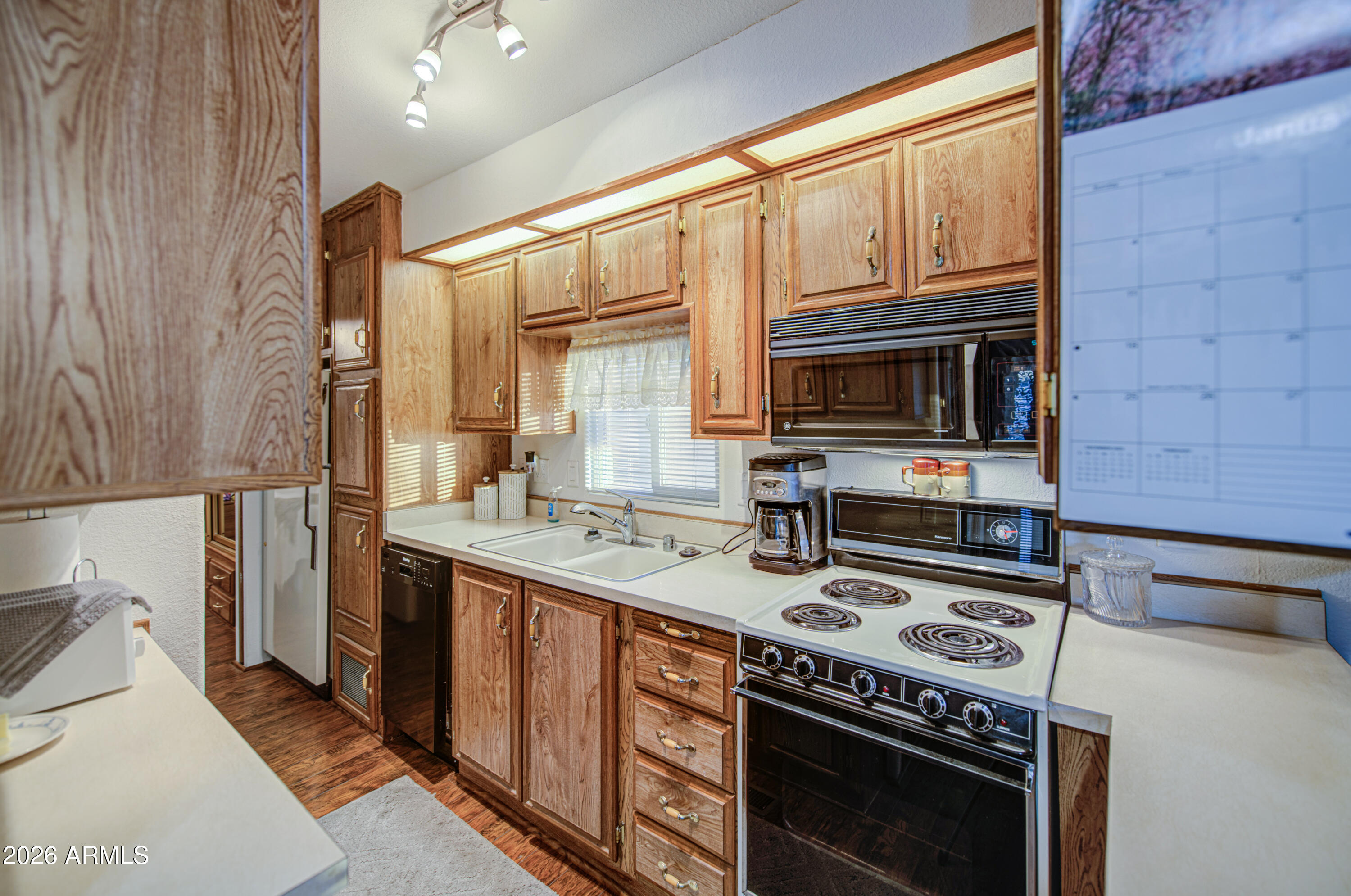 7750 East Broadway Road, Unit 349 Mesa, AZ 85208 - Photo 2 of 39 a kitchen with a stove a sink and a microwave