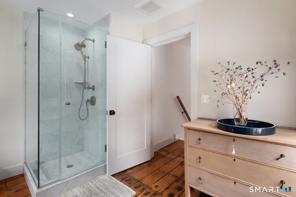 a bathroom with a granite countertop sink a shower and a mirror