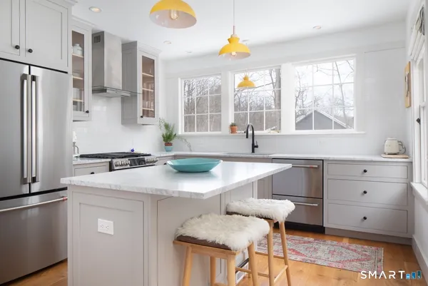 a kitchen with stainless steel appliances granite countertop a sink a stove and a refrigerator