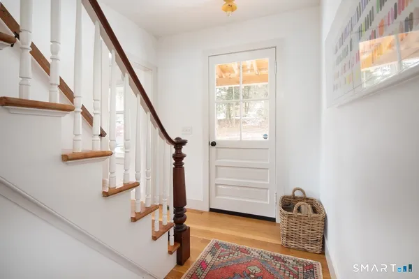 a view of hallway with stairs and wooden floor