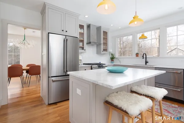 a kitchen with stainless steel appliances granite countertop a sink a stove and a refrigerator