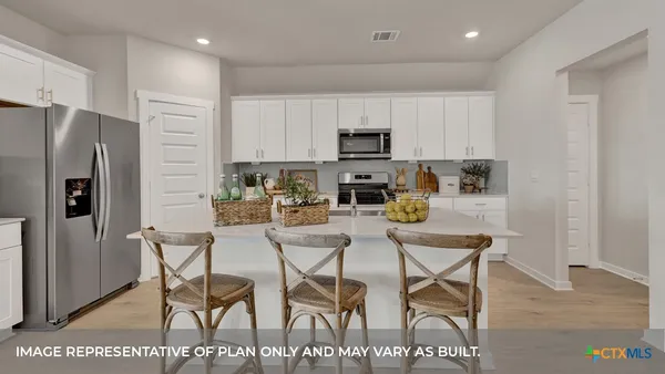 a kitchen with stainless steel appliances kitchen island granite countertop a refrigerator and microwave
