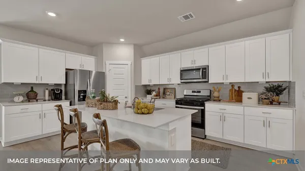 a kitchen with stainless steel appliances a stove a sink a microwave a refrigerator and cabinets