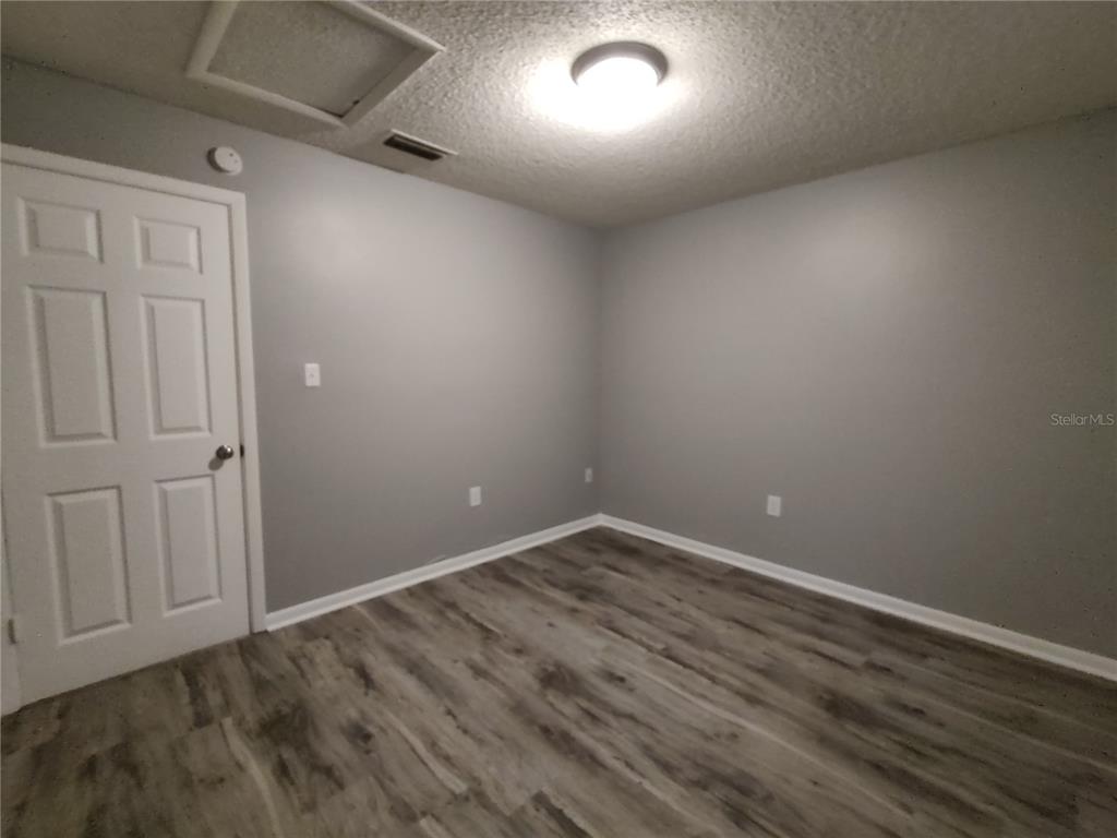 200 Church Street, Unit F2 Leesburg, FL 34748 - Photo 11 of 23 an empty room with wooden floor and windows