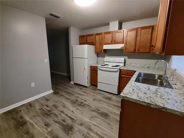 a kitchen with a stove a refrigerator and a sink