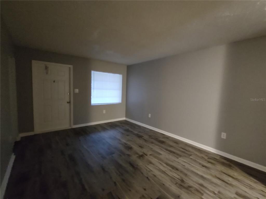 200 Church Street, Unit F2 Leesburg, FL 34748 - Photo 6 of 23 a view of an empty room with wooden floor and a window