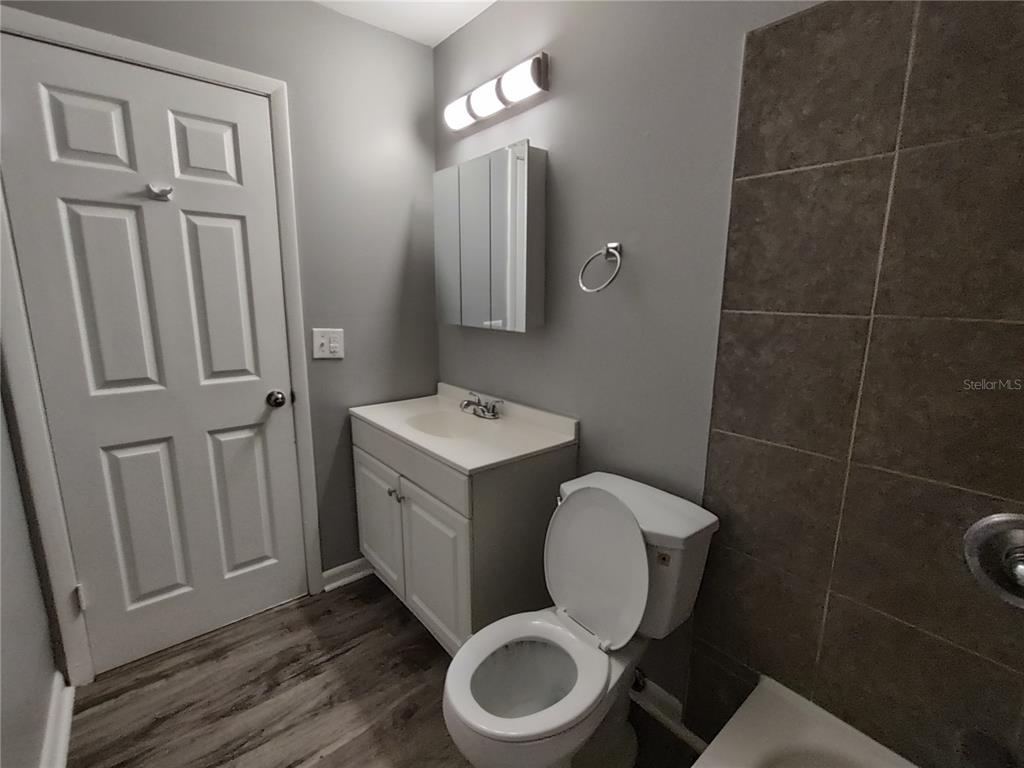 200 Church Street, Unit F2 Leesburg, FL 34748 - Photo 8 of 23 a bathroom with a toilet mirror vanity and toilet
