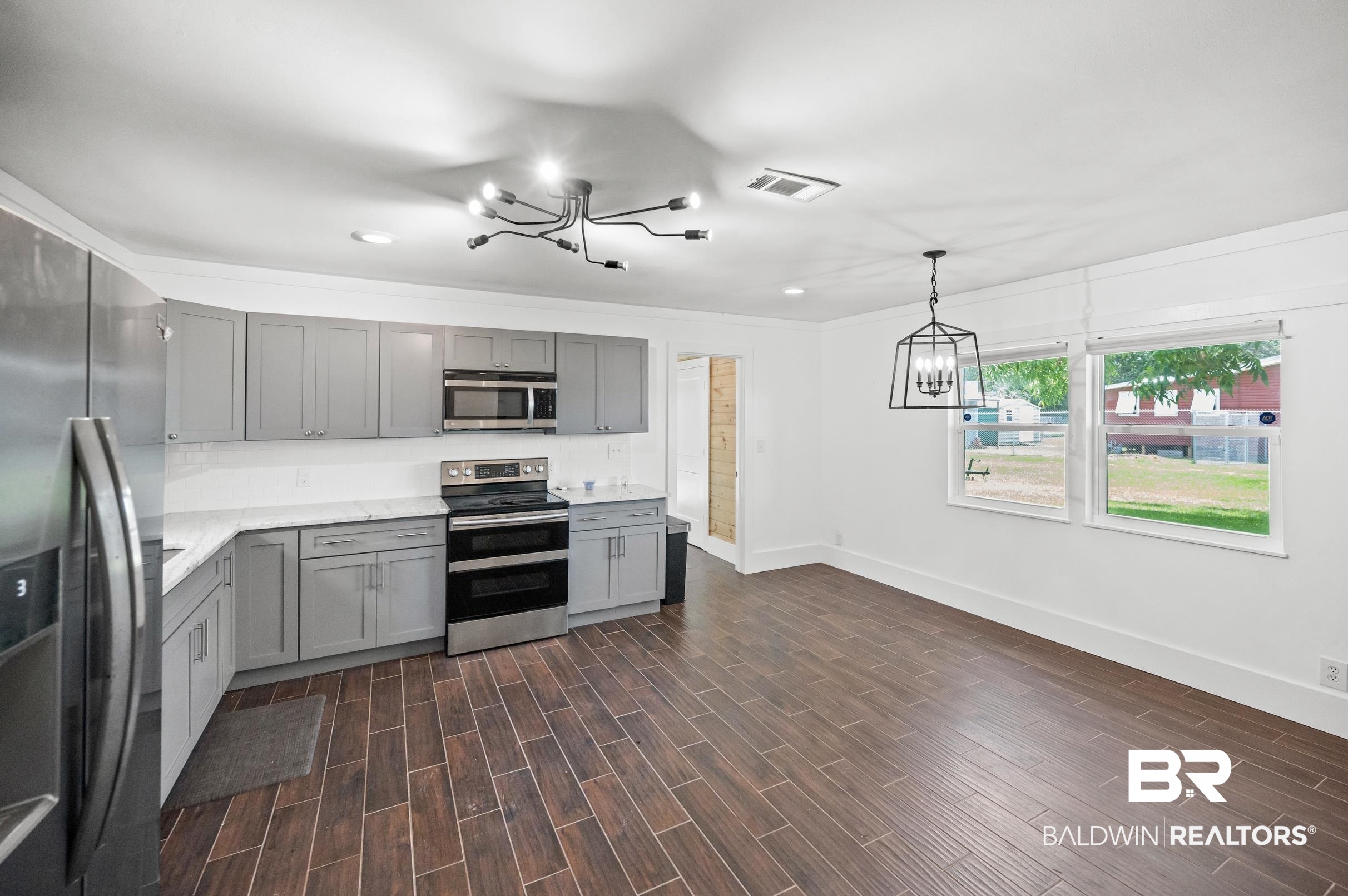 24663 Chestnut Street Elberta, AL 36530 - Photo 8 of 22 Modern kitchen featuring grey cabinetry, stainless steel appliances, and white countertops