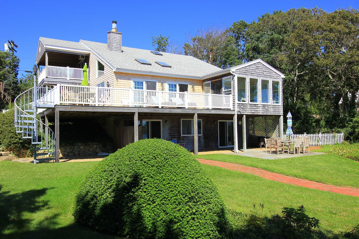 95 Hines Point Road Vineyard Haven, MA 02568 - Photo 2 of 43 a front view of a house with a yard table and chairs