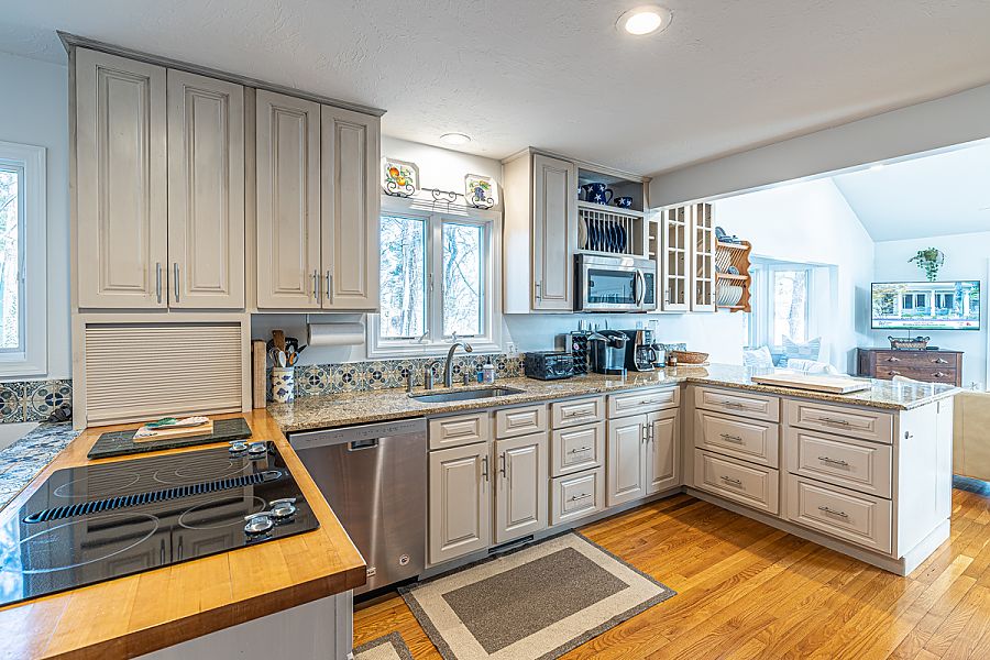 95 Hines Point Road Vineyard Haven, MA 02568 - Photo 22 of 43 a kitchen with stainless steel appliances granite countertop a stove a sink and a microwave