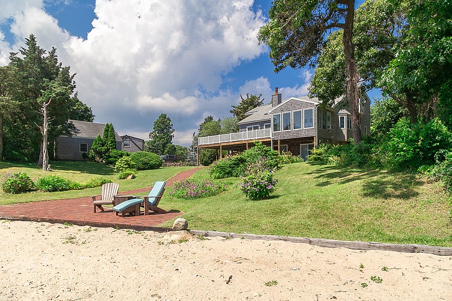 95 Hines Point Road Vineyard Haven, MA 02568 - Photo 6 of 43 a view of a garden with a bench in front of the house