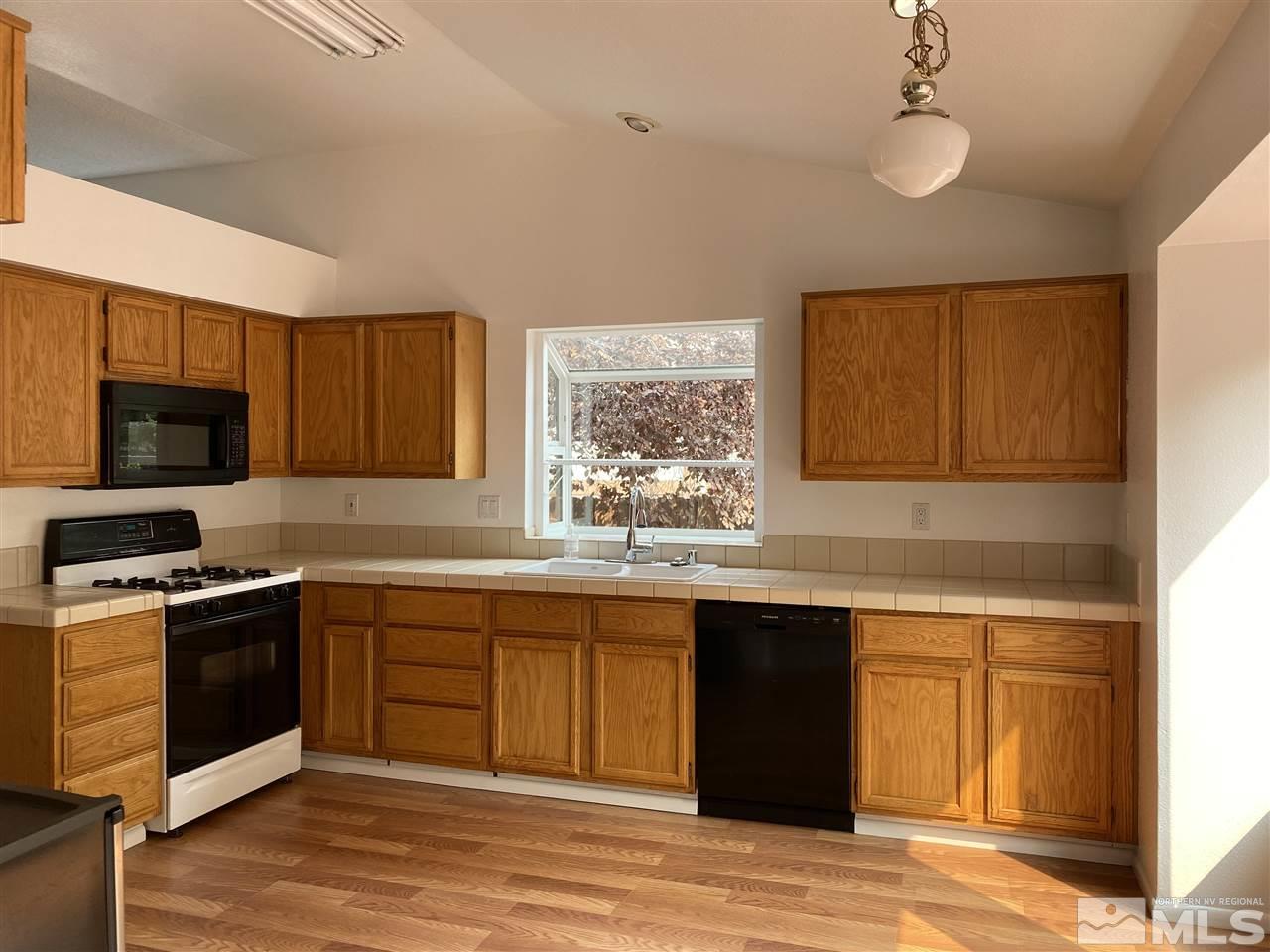 5236 Simons Drive Reno, NV 89523 - Photo 3 of 19 a kitchen with stainless steel appliances granite countertop a sink stove and refrigerator