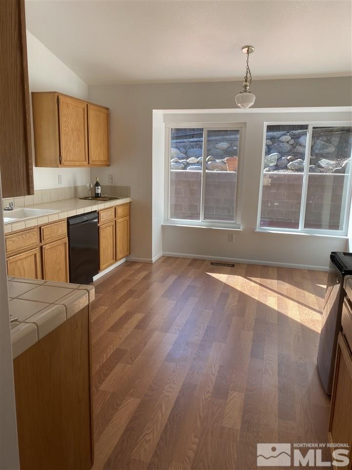 5236 Simons Drive Reno, NV 89523 - Photo 5 of 19 a kitchen with stainless steel appliances granite countertop a stove a sink and a granite counter tops with wooden floors