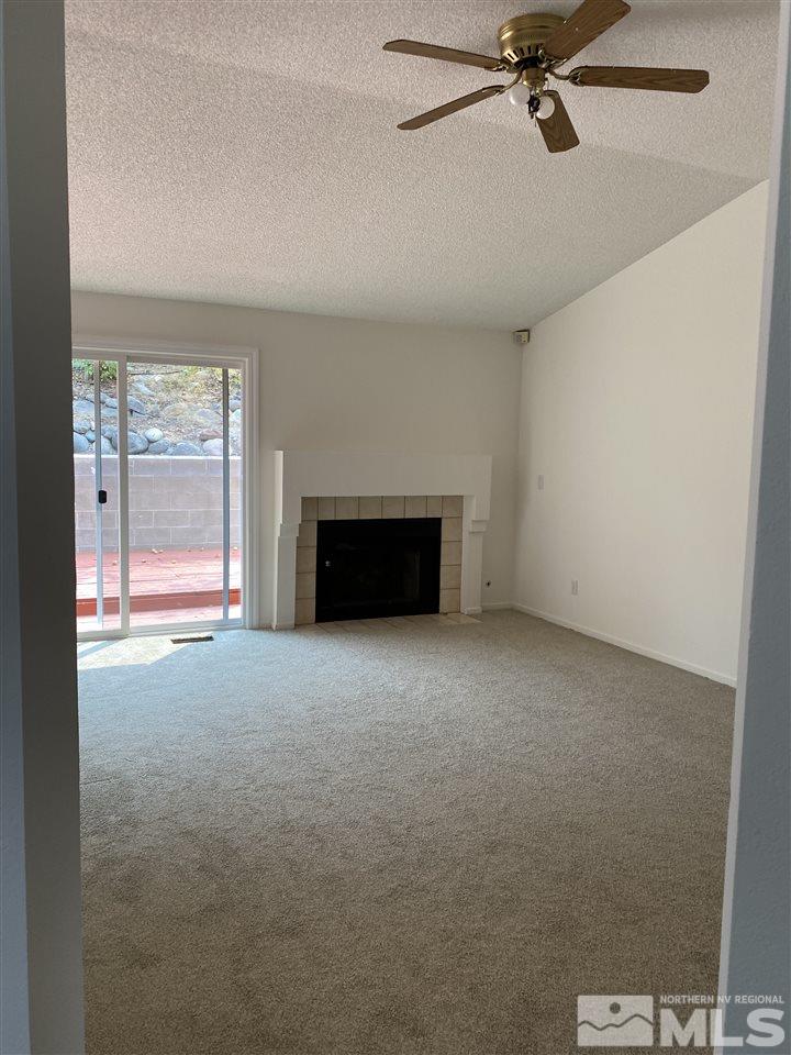 5236 Simons Drive Reno, NV 89523 - Photo 9 of 19 a view of an empty room with a fireplace and a window