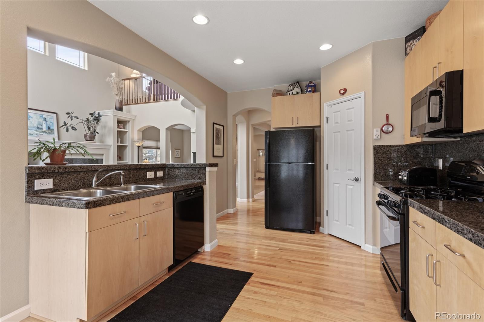4207 Frederick Circle Longmont, CO 80503 - Photo 11 of 35 a kitchen with stainless steel appliances granite countertop a refrigerator and a stove top oven