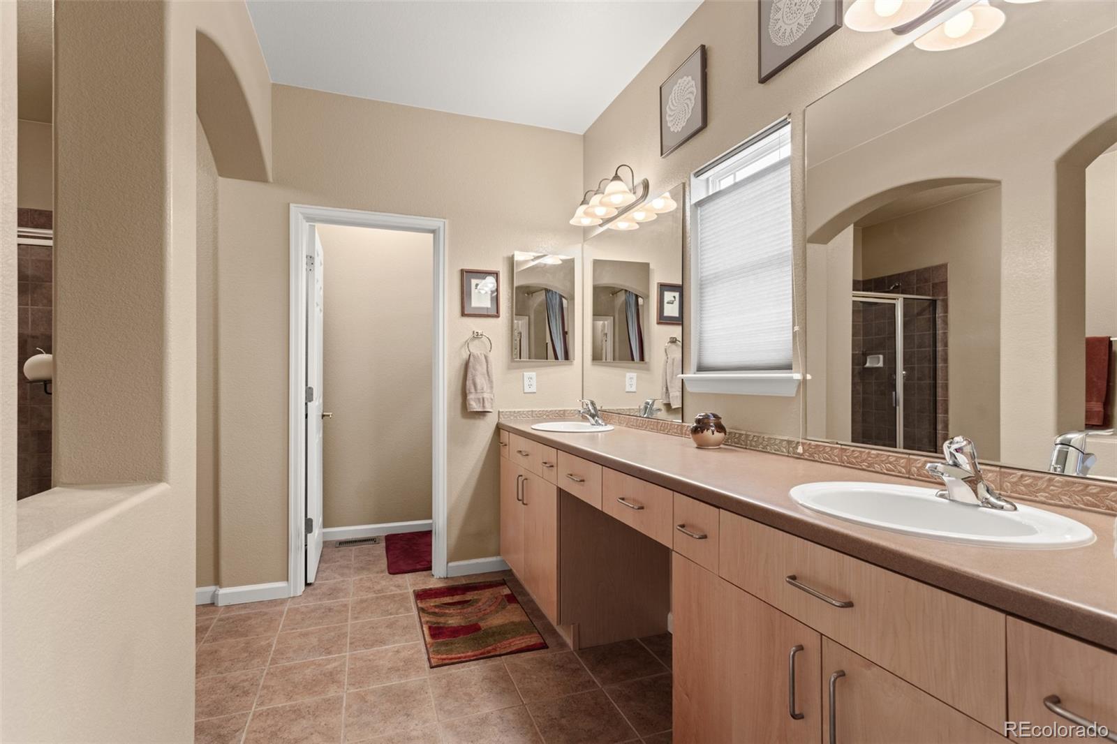 4207 Frederick Circle Longmont, CO 80503 - Photo 19 of 35 a spacious bathroom with a granite countertop sink and a mirror